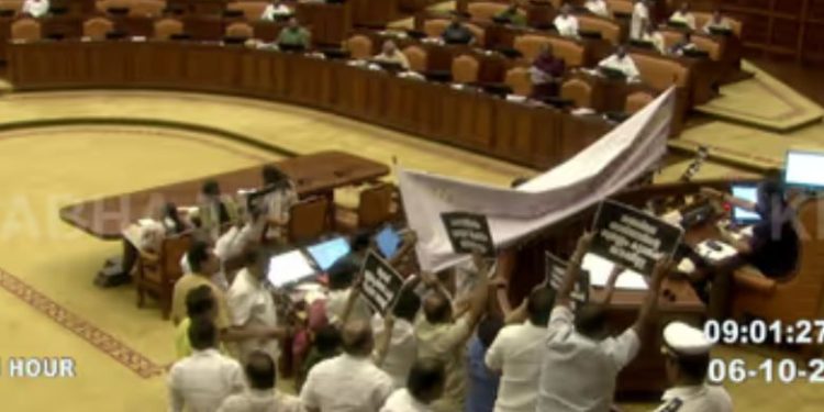 ശരണം വിളിച്ചെത്തി പ്രതിപക്ഷം, സ്പീക്കറുടെ ഇരിപ്പിടം മറച്ചു ബാനർ കെട്ടി, സഭ താൽകാലികമായി നിർത്തിവെച്ചു